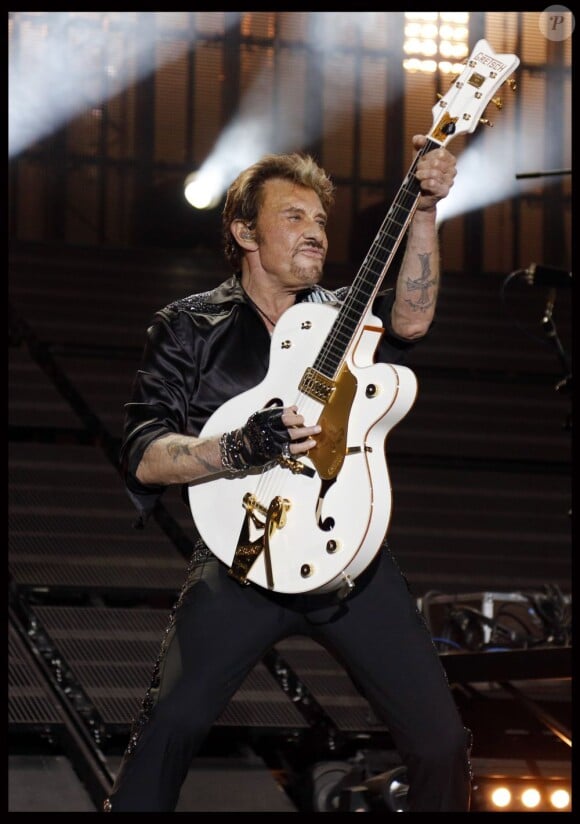 Johnny Hallyday et la fameuse guitare qu'on lui a dérobée, au Stade de France, le 15 juin 2012.