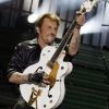 Johnny Hallyday et la fameuse guitare qu'on lui a dérobée, au Stade de France, le 15 juin 2012.