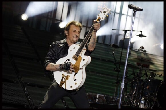 Johnny Hallyday et la fameuse guitare qu'on lui a dérobée, au Stade de France, le 15 juin 2012.