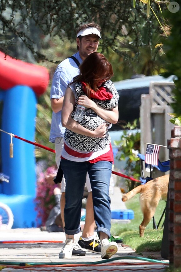 Alyson Hannigan protège sa petite Keeva Kane des photographes aux côtés de son mari Alexis Denisof lorsqu'ils célèbrent le 4 juillet avec leurs filles Satyana et Keeva à Brentwood le 4 juillet 2012