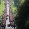 Le Long Walk était noir de monde. La reine Elizabeth II et son mari le prince Philip ont accueilli au château de Windsor la flamme olympique, le 10 juillet 2012, lors du 53e jour du relais de la torche olympique, assistant au passage de témoin entre Gina Macgregor et Phil Wells.