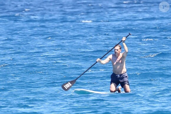 L'ancien ministre Eric Besson se laisse tenter par le paddle surfing au large de Saint-Tropez, le 12 juillet 2012.