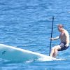 L'ancien ministre Eric Besson se laisse tenter par le paddle surfing au large de Saint-Tropez, le 12 juillet 2012.