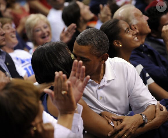 Michelle et Barack Obama assistent à un match de l'équipe olympique féminine de basket contre le Brésil et s'embrassent, à Washington, le 16 juillet 2012