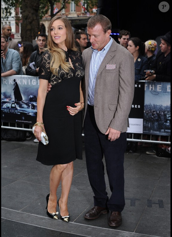 Guy Ritchie, fier, pose avec sa compagne Jacqui Ainsley, enceinte de son deuxième enfant, lors de l'avant-première du film The Dark Knight Rises, le 18 juillet 2012