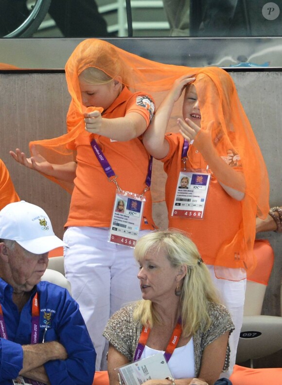 Catharina-Amalia et Alexia dans la fièvre oranje. Le prince Willem-Alexander et la princesse Maxima des Pays-Bas avec leurs filles les princesses Catharina-Amalia (8 ans), Alexia (7 ans) et Ariane (5 ans) dans les gradins de l'Aquatics Centre des Jeux olympiques de Londres le 29 juillet 2012, en feu devant la médaille d'argent des nageuses hollandaises dans le relais 4 x 100 m nage libre féminin.