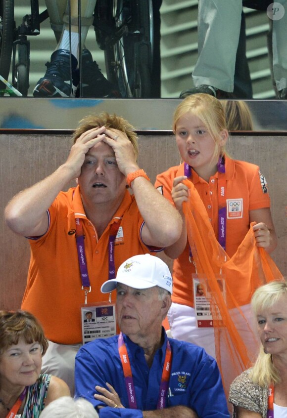 Le prince héritier se prend la tête à deux mains, mais les nageuses hollandaises ramènent tout de même de l'argent.
Le prince Willem-Alexander et la princesse Maxima des Pays-Bas avec leurs filles les princesses Catharina-Amalia (8 ans), Alexia (7 ans) et Ariane (5 ans) dans les gradins de l'Aquatics Centre des Jeux olympiques de Londres le 29 juillet 2012, en feu devant la médaille d'argent des nageuses hollandaises dans le relais 4 x 100 m nage libre féminin.