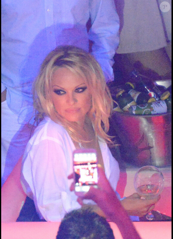 La pauvre Pamela Anderson semble épuisée par le champagne alors qu'elle fait la fête au Vip Room de Saint Tropez le 31 juillet 2012 et les fans ne la laissent pas tranquille