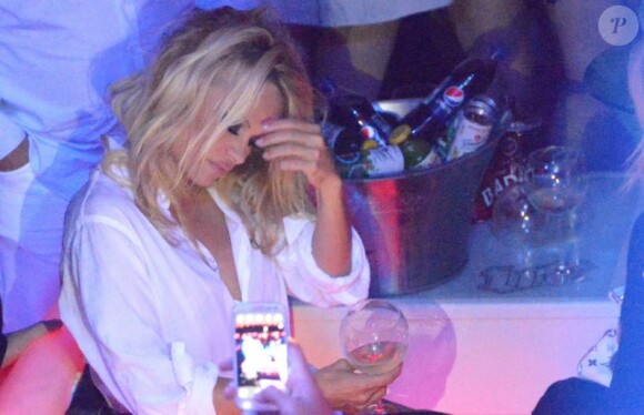 Pamela Anderson, légèrement assommée par le champagne, fait la fête au Vip Room de Saint Tropez le 31 juillet 2012