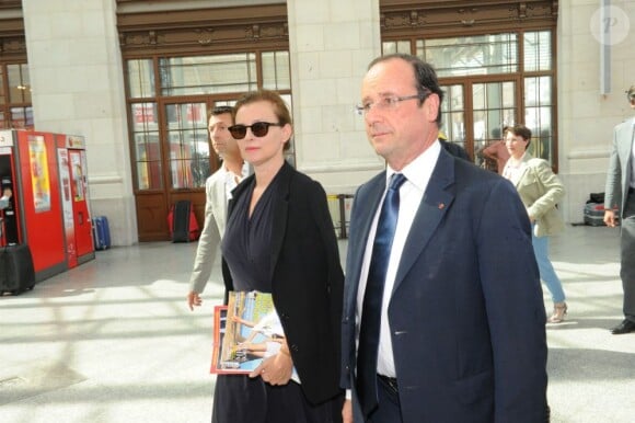 François Hollande et Valerie Trierweiler, enthousiastes à l'idée de partir pour le Fort de Brégançon en TGV à la gare de Lyon le 2 août 2012 à Paris