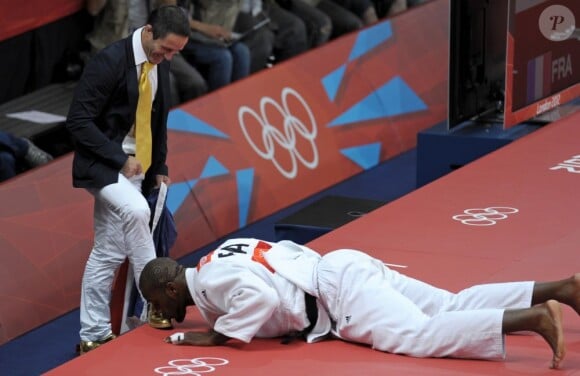 Teddy Riner embrasse les chaussures en or de son coach Benoit Campargue après avoir décroché l'or olympique le 3 août 2012 à Londres