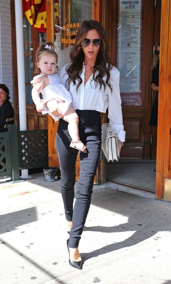 Entièrement habillée des vêtements de sa dernière collection, Victoria Beckham quitte le restaurant Pastis avec sa fille Harper dans les bras. New York, le 11 septembre 2012.