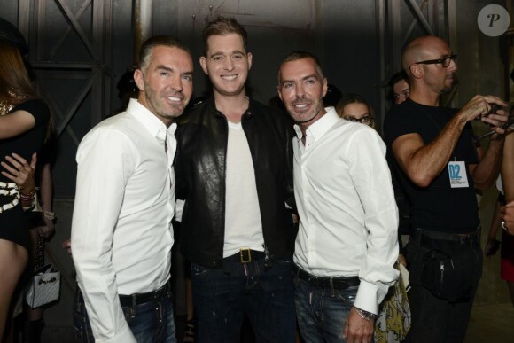 Michael Bublé entouré des jumeaux Dean et Dan Caten, créateurs de la marque DSquared2, à leur défilé à Milan, le 24 septembre 2012.
