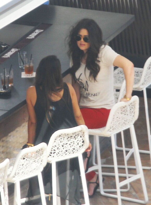 Kim Kardashian et sa soeur Khloé discutent autour d'un verre. Miami, le 11 octobre 2012.