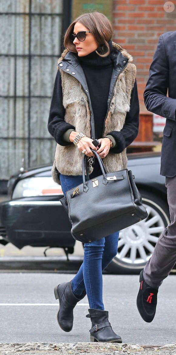 Olivia Palermo à New York, porte des lunettes Dior, une veste en fourrure et un pull en cachemire Zadig & Voltaire, un jean slim, des bottines noires et un sac Hermès. Le 8 octobre 2012.