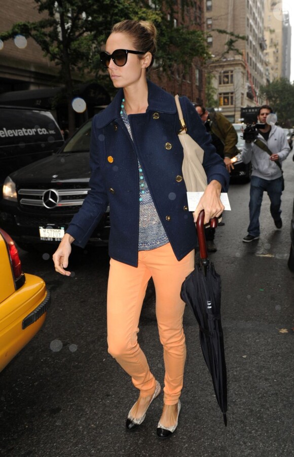 Stacy Keibler joue les Audrey Hepburn moderne sous la pluie new-yorkaise avec un caban Tory Burch, un sac crème Yves Saint Laurent, un jean orange et des ballerines. New York, le 9 octobre 2012.