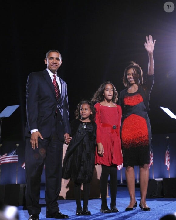Sasha et Malia Obama dans des tenues assorties à celles de leurs parents. En rouge et noir, les Obama ont du style ! Chicago, en 2008
