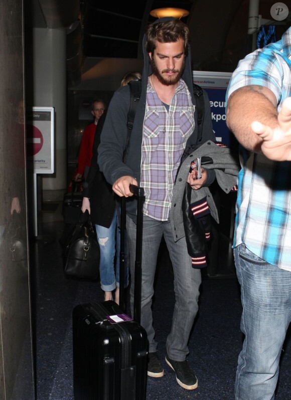 Andrew Garfield suivi d'Emma Stone à l'aéroport de Los Angeles, le 16 novembre 2012.