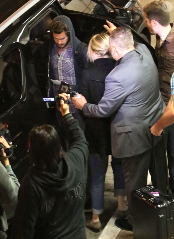 Emma Stone et Andrew Garfield entourés de photographes arrivent à l'aéroport de Los Angeles, le 16 novembre 2012.