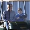Harrison Ford, attentif pendant que son fils Liam conduit une petite golfette avant de prendre l'avion, le 25 novembre 2012.