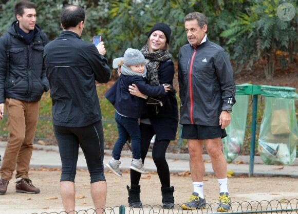 Nicolas Sarkozy s'arrête pour des photos alors qu'il fait son footing au Parc Monceau à Paris le 28 novembre 2012.