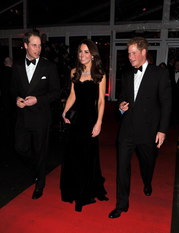 La duchesse de Cambridge Kate Middleton, ravissante dans sa robe noire Alexander McQueen et bien entourée avec son mari le prince William et de son beau-frère le Prince Harry lors de la soirée A Night of Heroes à Londres. Le 19 décembre 2012.