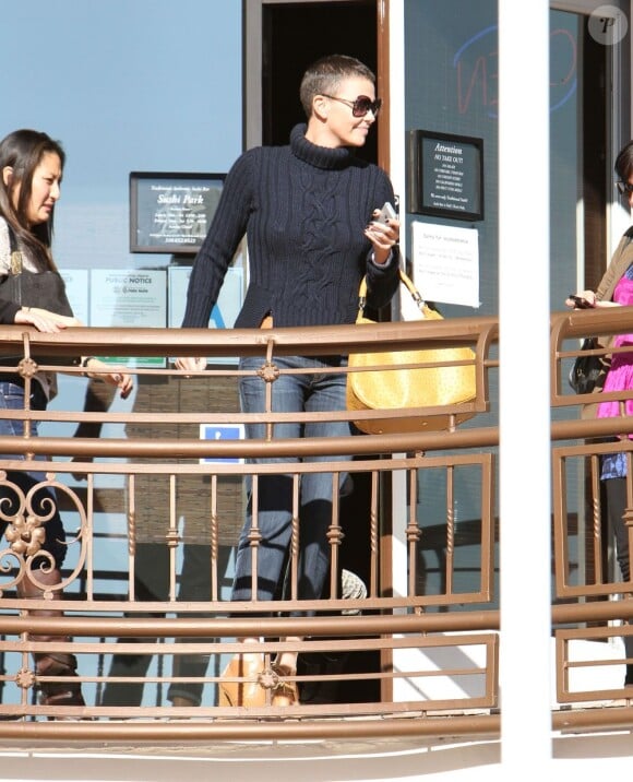 Charlize Theron affiche sa coupe garçonne brune avec le sourire et ses amis à West Hollywood, le 20 décembre 2012.