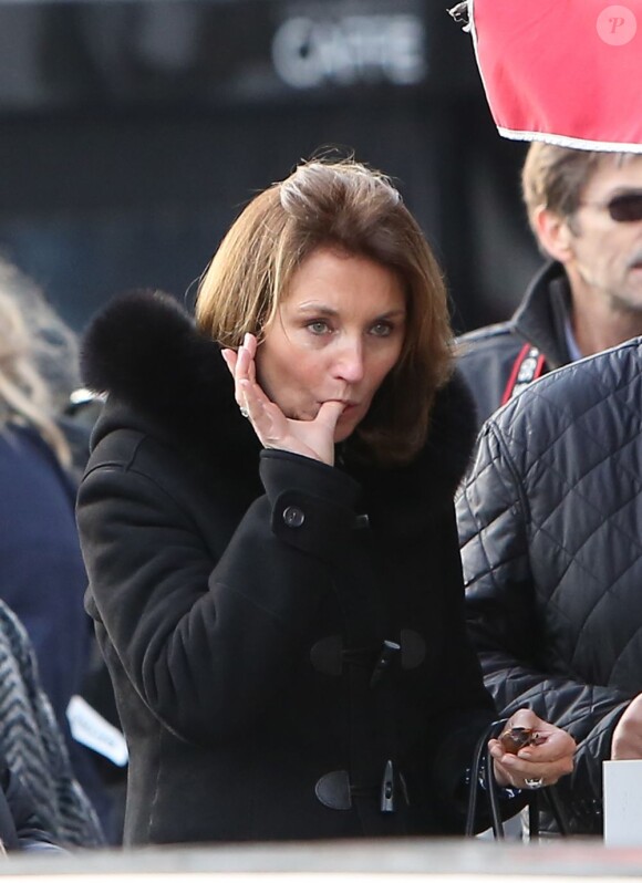 Cécilia Attias se lèchent les doigts après avoir mangé un petit marron chaud devant le café des Deux Magots, le 15 décembre 2012 à Paris