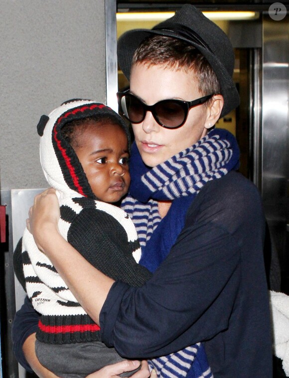Charlize Theron, son fils Jackson et sa maman Gerda arrivent à l'aéroport de Los Angeles le 6 janvier 2013. la maman tient fermement son fils dans les bras.
