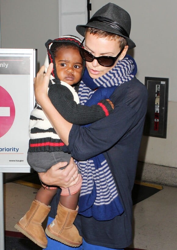 Charlize Theron, son fils Jackson et sa maman Gerda arrivent à l'aéroport de Los Angeles le 6 janvier 2013. Le petit garçon regarde avec curiosité ce qui l'entoure.