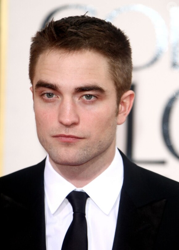 Robert Pattinson face aux photographes pendant les Golden Globes Awards 2013 à Los Angeles, le 13 janvier 2013.