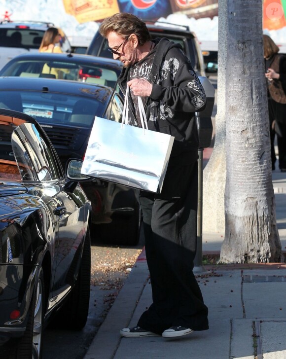 Johnny Hallyday charge la voiture après avoir fait du shopping en famille dans le quartier de Pacific Palisades, à Los Angeles, le 14 février 2013.