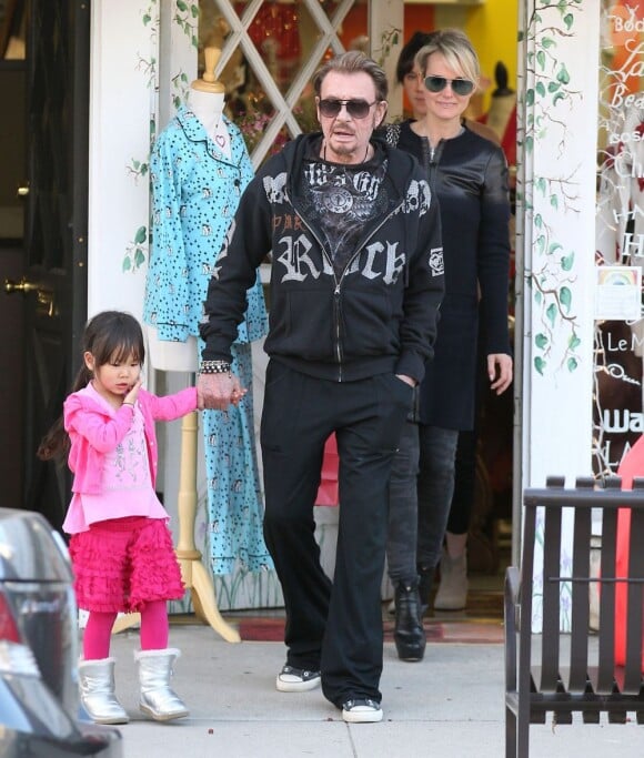 Johnny Hallyday et Laeticia quittent une boutique avec leurs filles - ici la petite Jade - dans le quartier de Pacific Palisades, à Los Angeles, le 14 février 2013.