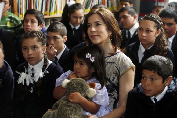 La princesse Mary de Danemark visite une école à Valparaiso, deuxième ville du Chili, le 12 mars 2013. Élégante, elle n'a pas hésité à prendre une jeune fille sur ses genoux.