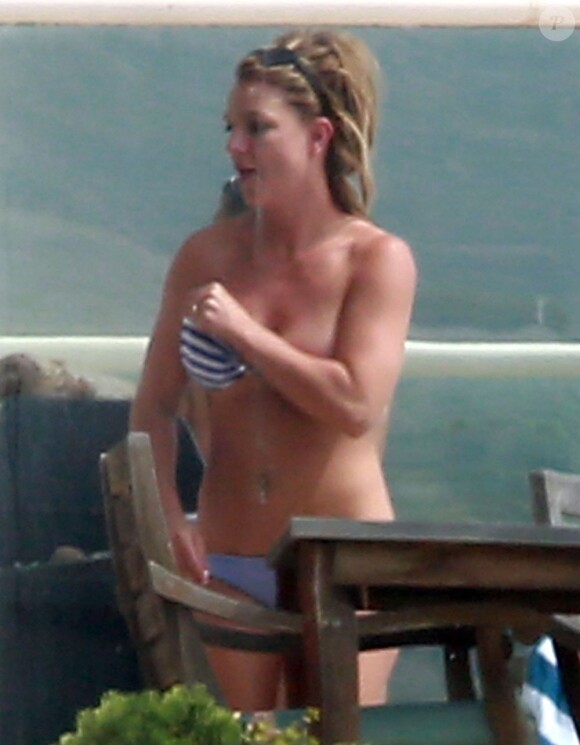 Britney Spears profite du soleil en maillot de bain et en fumant quelques cigarettes, au bord d'une piscine chez des amis, après avoir déjeuné au Cafe Habana à Malibu, le 25 mars 2013.
