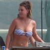 La chanteuse Britney Spears profite du soleil en maillot de bain et en fumant quelques cigarettes, au bord d'une piscine chez des amis, après avoir déjeuné au Cafe Habana à Malibu, le 25 mars 2013.