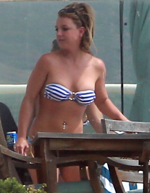 La chanteuse Britney Spears profite du soleil en maillot de bain et en fumant quelques cigarettes, au bord d'une piscine chez des amis, après avoir déjeuné au Cafe Habana à Malibu, le 25 mars 2013.