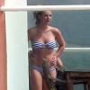 Britney Spears profite du soleil en maillot de bain et en fumant quelques cigarettes, au bord d'une piscine chez des amis, après avoir déjeuné au Cafe Habana à Malibu, le 25 mars 2013.