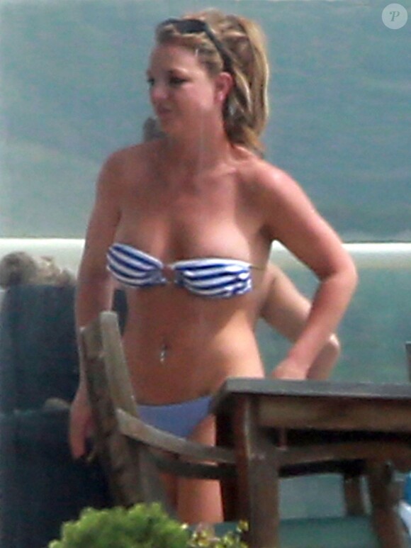 Britney Spears, au top, profite du soleil en maillot de bain et en fumant quelques cigarettes, au bord d'une piscine chez des amis, après avoir déjeuné au Cafe Habana à Malibu, le 25 mars 2013.