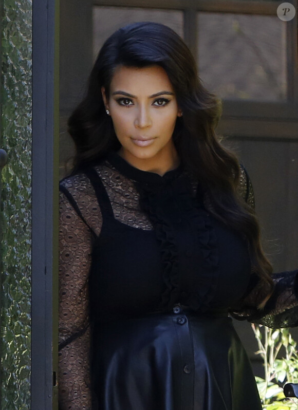 Kim Kardashian, enceinte et tout de noir vêtue avec un chemisier transparent, une jupe en cuir et des souliers Jimmy Choo, quitte sa maison. Beverly Hills, le 28 mars 2013.