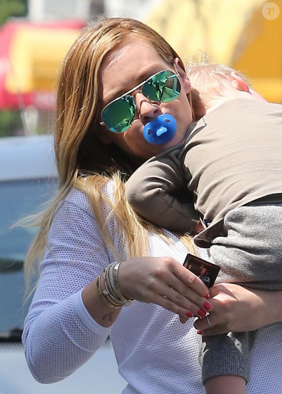 Hilary Duff porte son fils Luca qui dort sur son épaule à Studio City, le 26 mars 2013.