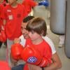 Brahim Asloum, boxeur heureux au milieu des enfants à l'occasion de la journée Sporteens Sunday dans la salle Sweat Boxing du champion, le 14 avril 2013