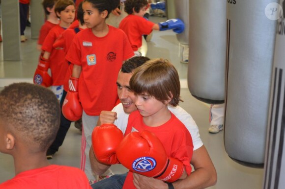 Brahim Asloum, boxeur heureux au milieu des enfants à l'occasion de la journée Sporteens Sunday dans la salle Sweat Boxing du champion, le 14 avril 2013