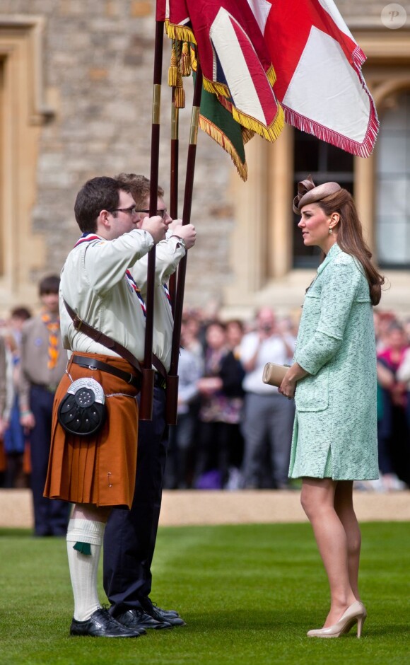 Kate face aux porte-étendard, distingué pour leur bravoure. Kate Middleton, duchesse de Cambridge, enceinte de 6 mois et resplendissante dans un manteau Mulberry, lors de la revue nationale des Queen's Scouts au château de Windsor, le 21 avril 2013. Une mission confiée par la reine Elizabeth II.