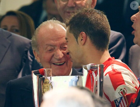 Le roi Juan Carlos Ier d'Espagne heureux de remettre le trophée à Gabi Fernandez, capitaine de l'Atletico, le 17 mai 2013 à Santiago Bernabeu à l'issue de la finale de la Coupe du Roi, marquée par la victoire de l'Atletico aux dépens du Real, 2-1 après prolongations.