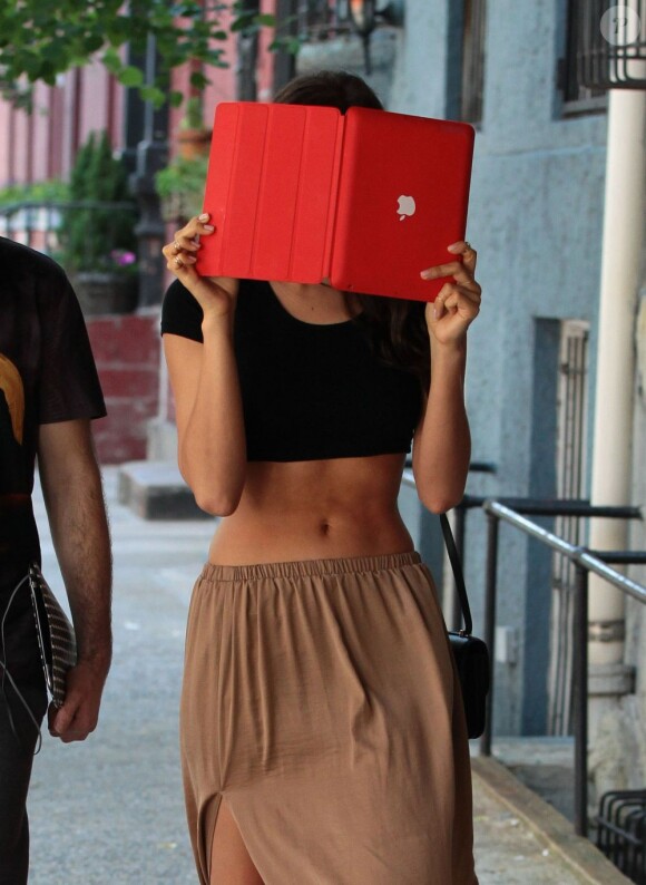 Hostile aux photographes, Irina Shayk se cache derrière sa tablette tactile. New York, le 2 juin 2013.
