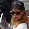 La chanteuse Rihanna se voit offrir un cadeau par un fan alors qu'elle sort de son hôtel à Amsterdam, le 23 juin 2013