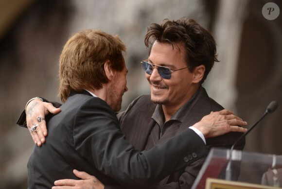 Johnny Depp saluant Jerry Bruckheimer après lui avoir fait un discours lors de la remise de son étoile sur Hollywood Boulevard à Los Angeles le 24 juin 2013