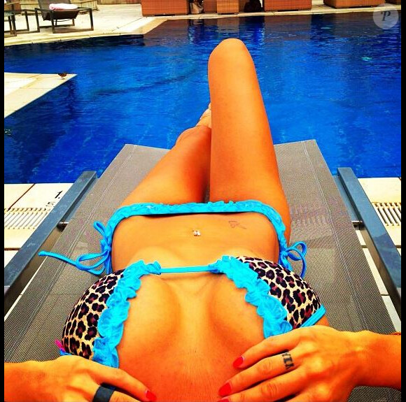 Les vacances selon Shauna Sand, sexy en bikini et allongée sur un transat.