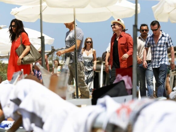 Le chanteur Bono, bien entouré, arrive au Club 55, plage de Pampelonne à Ramatuelle, le 04 juillet 2013.